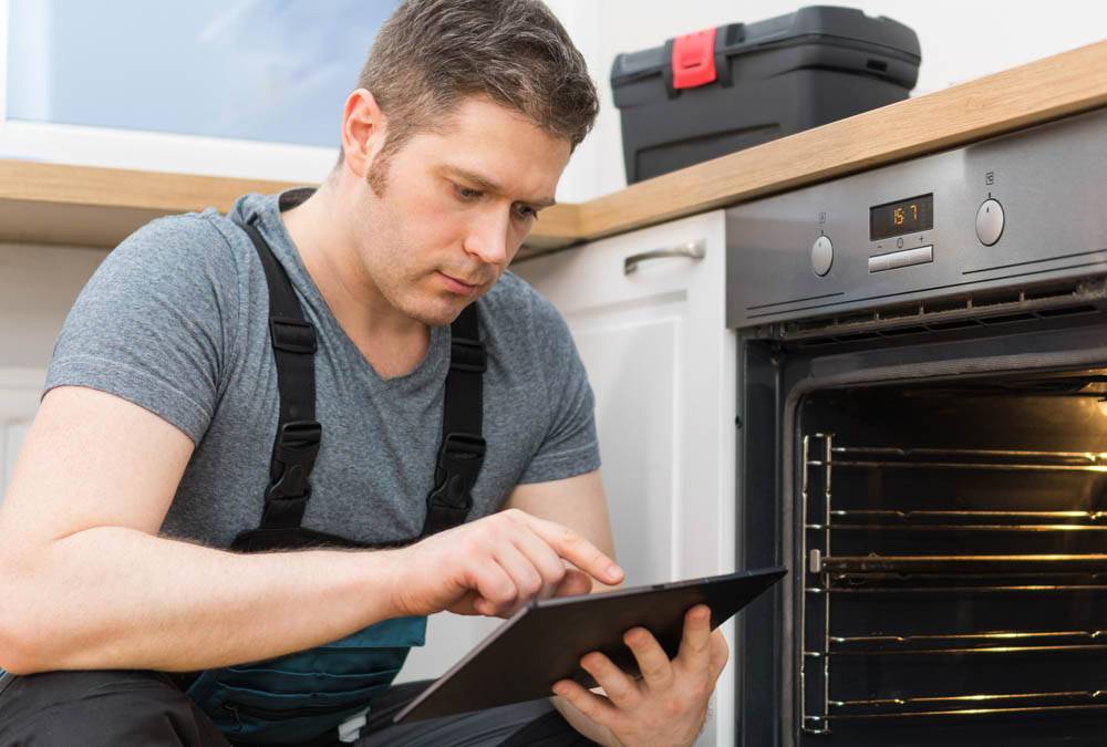 man repairing oven