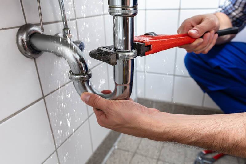 plumber adjusting pipe