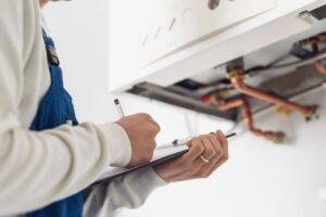 Man carrying out boiler services with clipboard